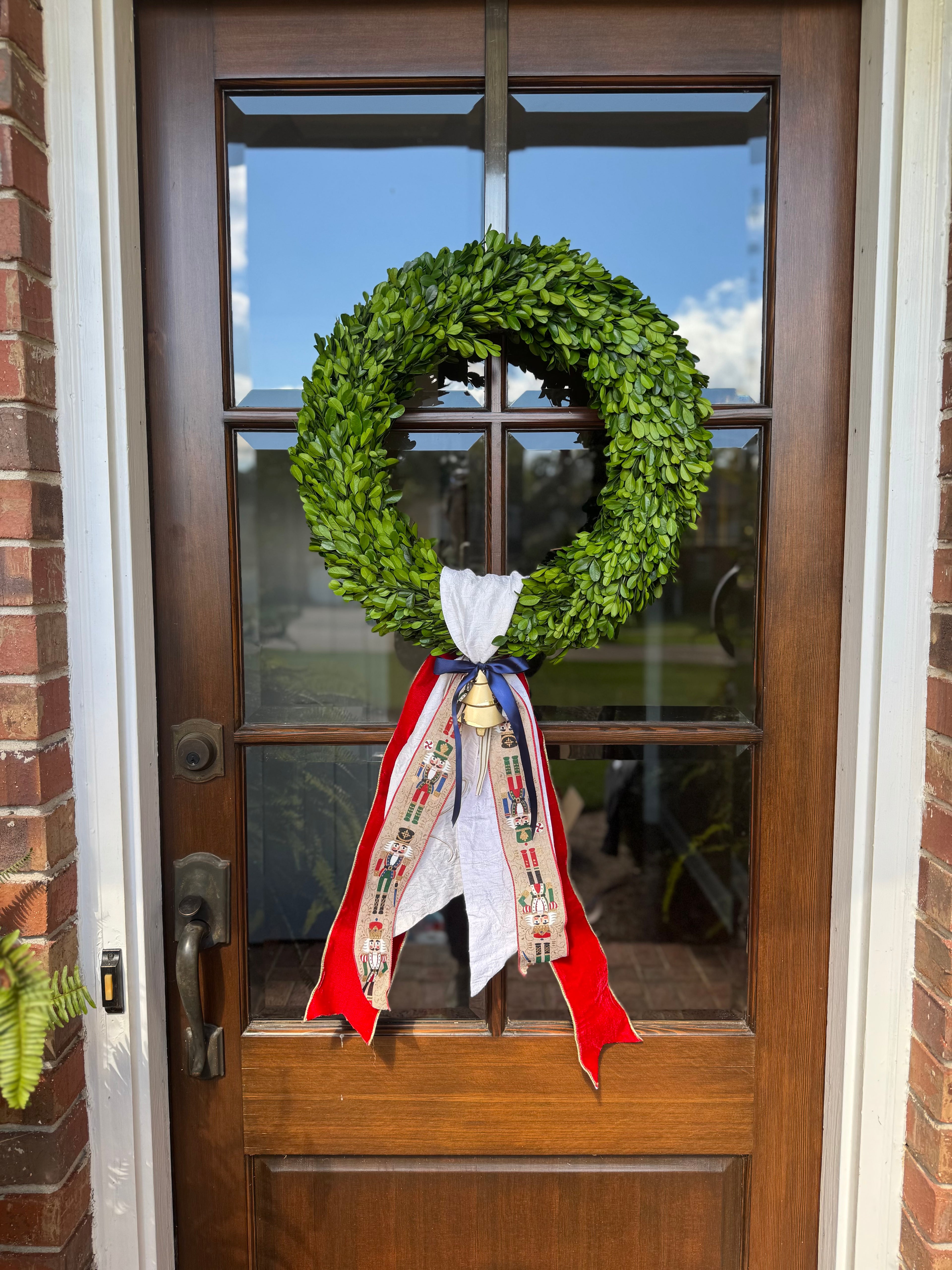 Boxwood wreath with Christmas sash and a wreath ornament